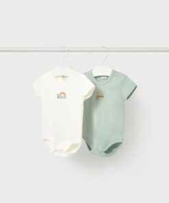 Two baby onesies hanging on a metal rod white with a pastel rainbow and bunny design and a mint green one with small yellow embroidery