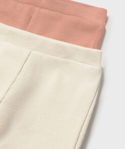 Close up of cream corduroy pants with a pink elastic waistband edge visible at the top