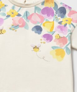 White tee with a colorful floral pattern across the upper chest and small bees nearby the center area of the print