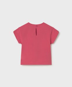 Back view of a pink short sleeve top for a child with a small button and keyhole at the neckline