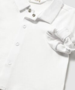 White polo shirt for a baby with a fabric flower detail on the chest