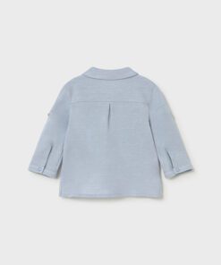 Back view of a light blue long sleeve childrens shirt with a center back pleat and buttoned cuffs