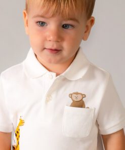 Toddler in a white polo shirt with a teddy bear in the chest pocket and a giraffe toy peeking from the side pocket