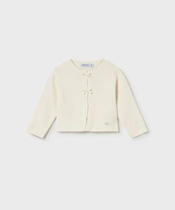 Cream cardigan for a child with two fabric bow ties at the front