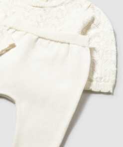 Cream knitted sweater with delicate lace pattern paired with matching cream knit pants laid flat on a light background