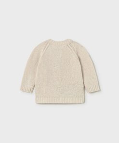 Cream knitted sweater with ribbed cuffs and hem laid flat