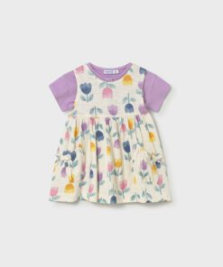 Toddler dress with lavender short sleeves, cream background, multicolor floral print, and two side pockets with bows.
