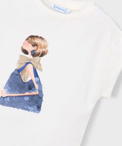 White T shirt featuring a stylized illustration of a woman with a beige bow and a blue sequined handbag