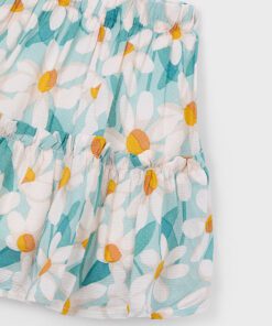 Light blue floral skirt with white daisies and yellow centers featuring an elastic waist and gathered tiers