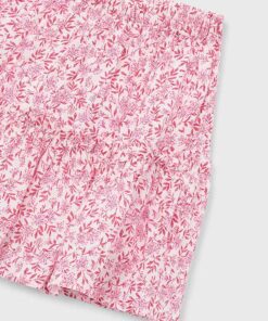 Close up of pink floral patterned fabric showing an elastic waistband likely shorts with small pink flowers and leaves on white