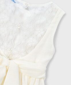 Cream colored lace bodice with a sheer floral lace overlay and a tied belt at the waist close up detail of a dress top