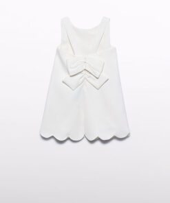 White sleeveless dress for a child with a large back bow and scalloped hem displayed flat against a white background