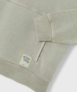 Light gray hoodie sleeve with a ribbed cuff and a tag that reads Growing up isnt boring