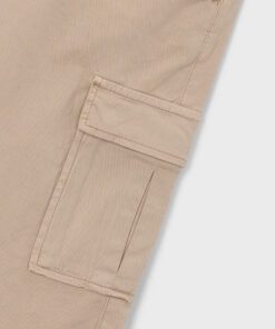 Beige cargo pant leg with a rectangular patch pocket and flap showing reinforced stitching detail on the seam.